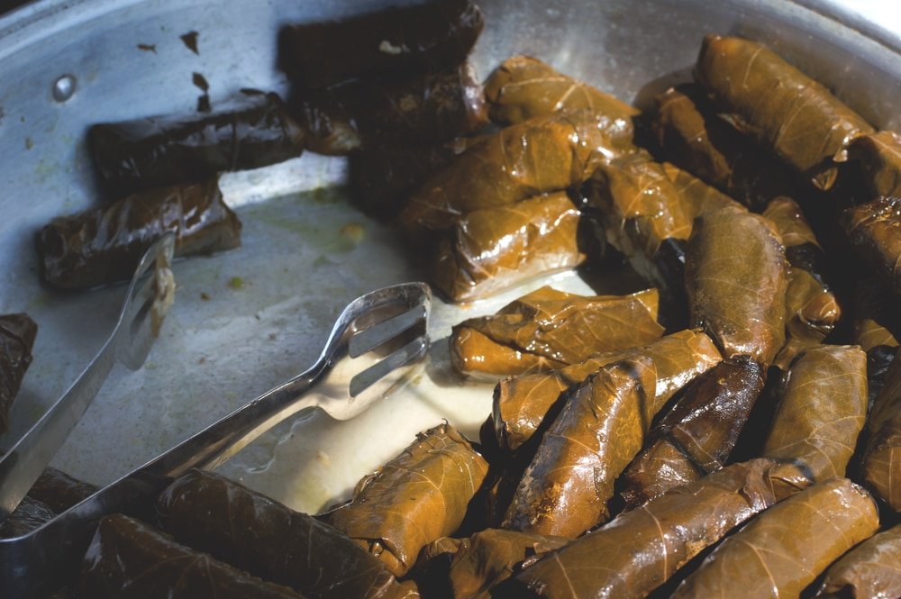 Find Athens street foods like Dolma, greek traditional appetizer. selective focus stuffed vine leaves for sale on market. Close-up. Top view