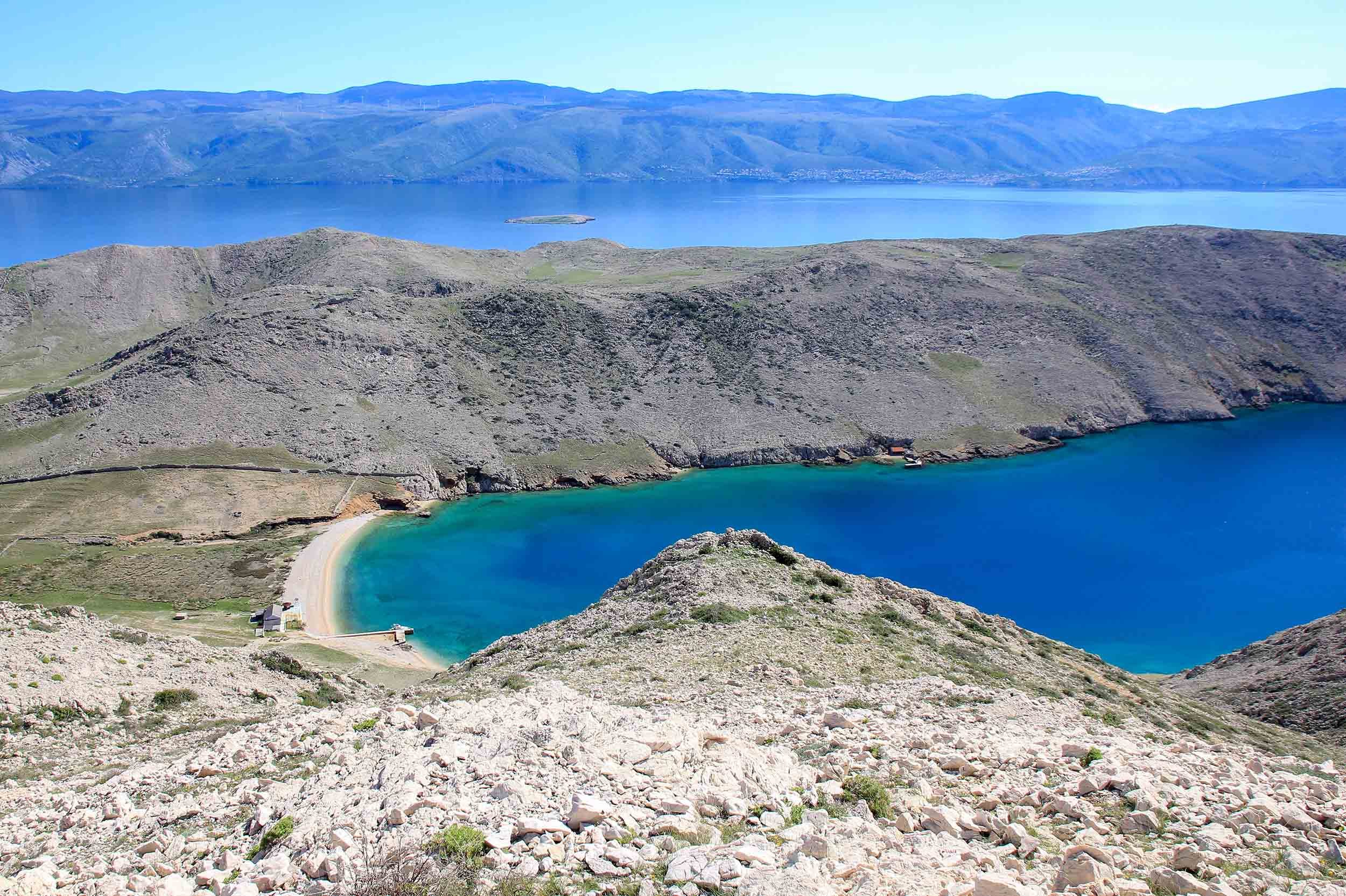 In Croatia, a blue lake is seen from the top of a mountain in spring.