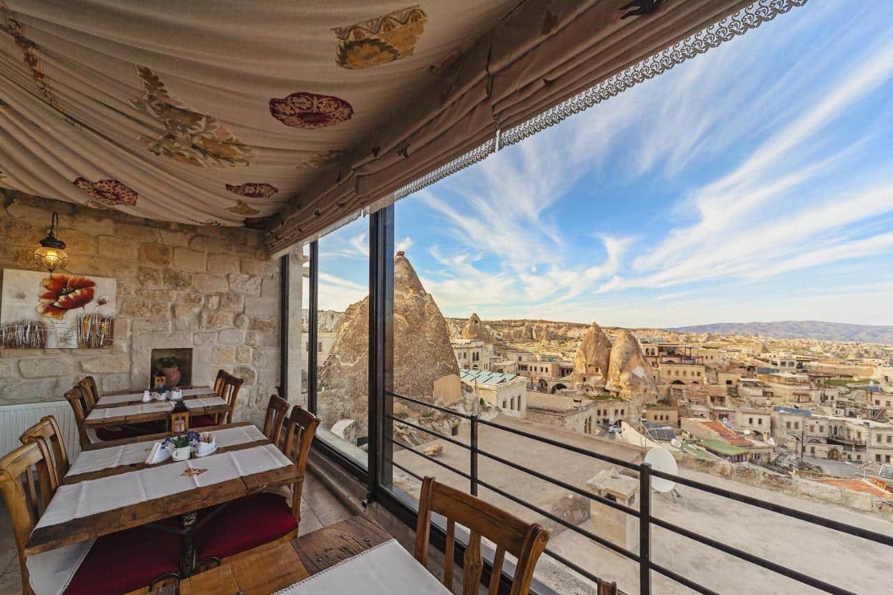 A luxury restaurant with tables and chairs overlooking the balloon take off from Mithra Cave Cappadocia