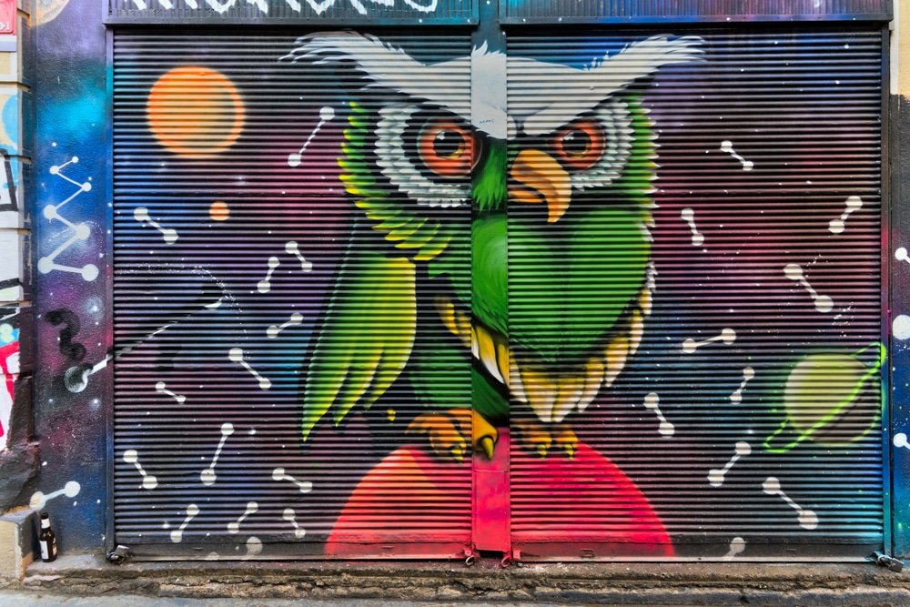 Closed shop exterior with metal door covered with colorful graff