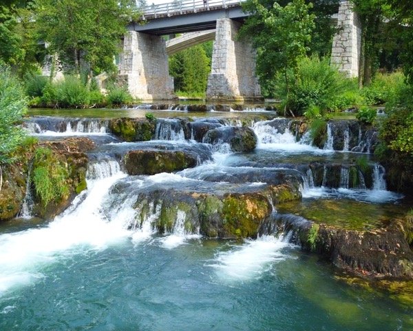 A picturesque waterfall cascading over a bridge in Croatia during spring - Rastoke