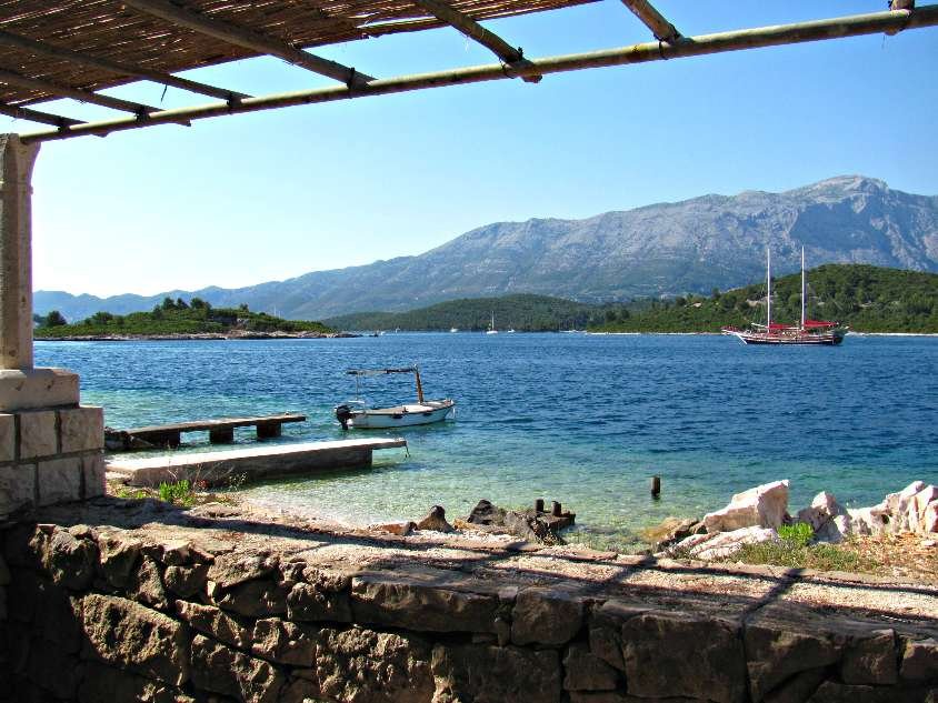 A picturesque stone wall stretching alongside the tranquil body of water in Korcula.