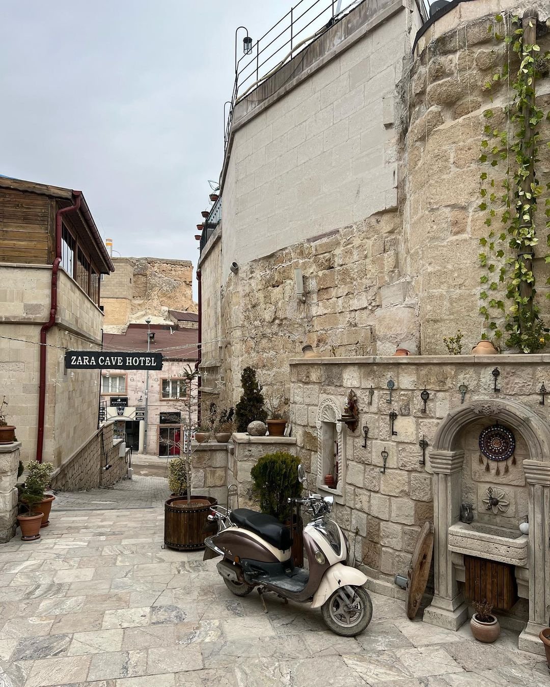 A luxury scooter is parked in a stone alley in Cappadocia near Zara Cave Hotel